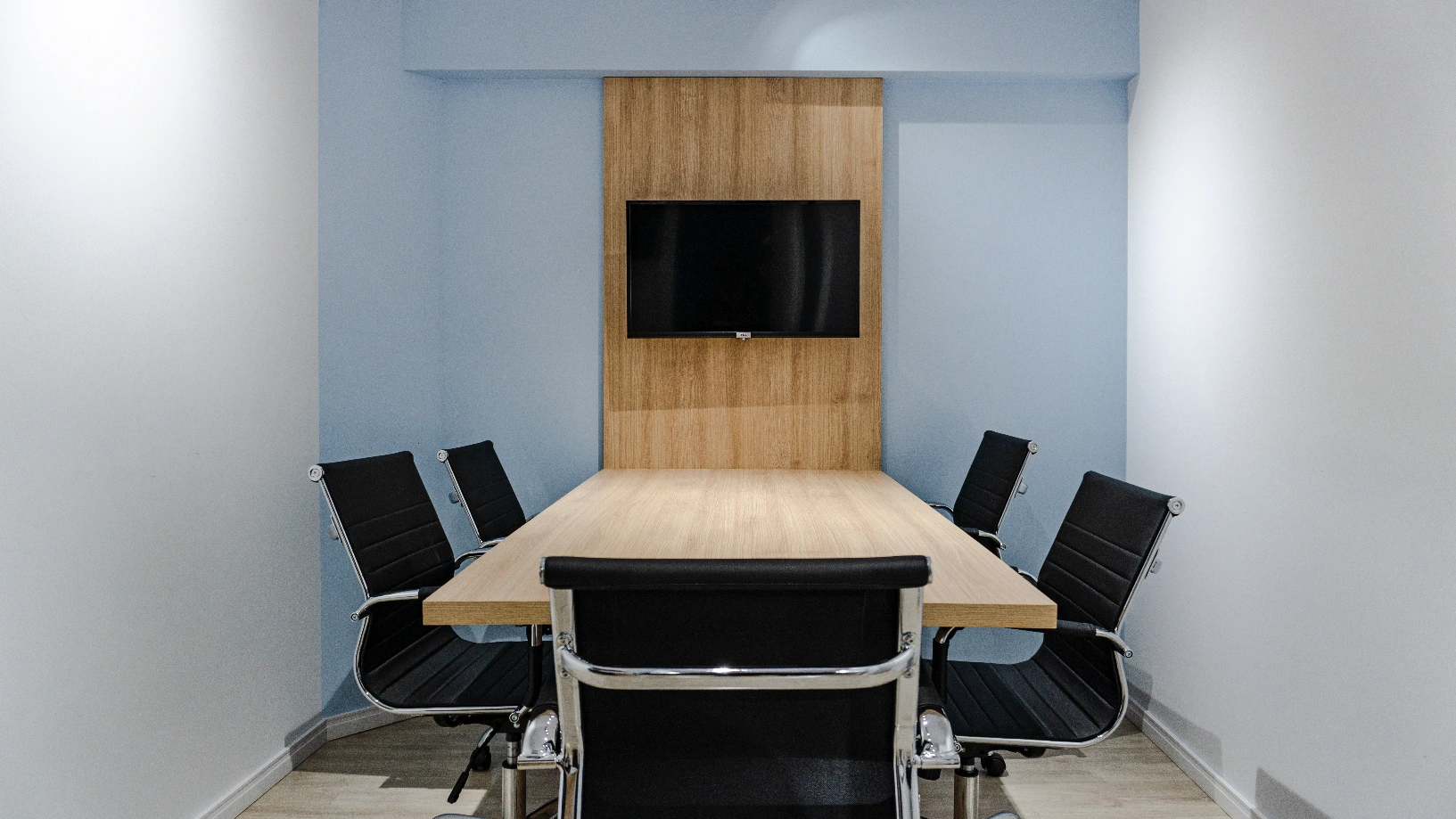 Sala de reunião da Jorge Brum Advocacia, com a logomarca oficial na TV